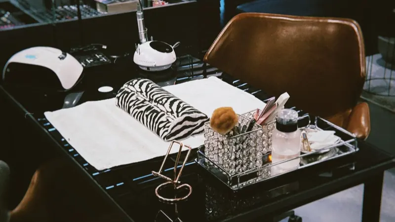 The Nails on Art work table with a nail lamp, tools and a zebra-print towel