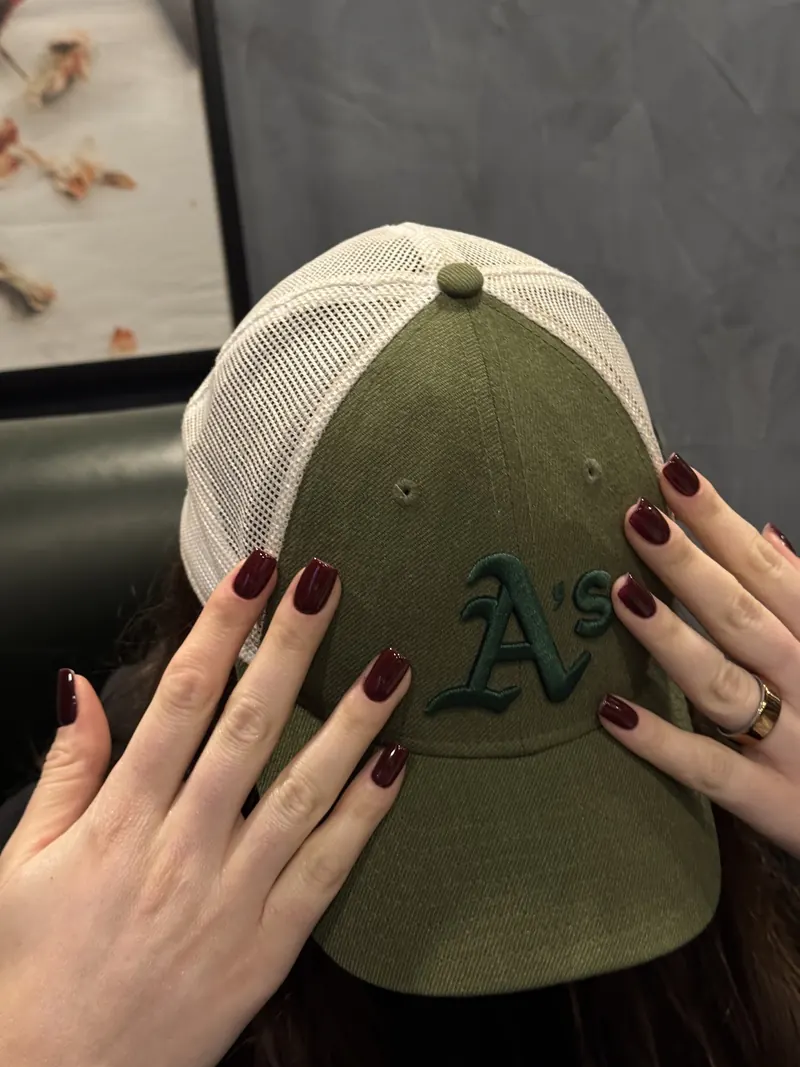 Short bordeaux nails on a green cap